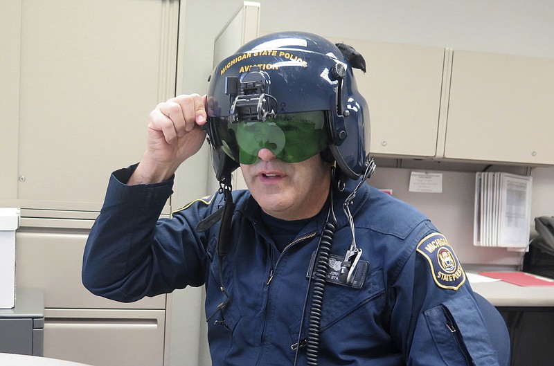 
              In a March 14, 2017 photo, Michigan State Police pilot Jerry King, shows a anti-laser shield in his office at a state police facility at Capital Region International Airport, in Lansing, Mich. Pilots use the anti-laser shield on their helmet when they are trying to pinpoint the source of a laser that is being shined at them or other aircraft. Michigan is poised to join a growing list of states and enact its own stiff law that criminalizes increasingly frequent laser attacks that are endangering pilots and their passengers. (AP Photo/David Eggert)
            
