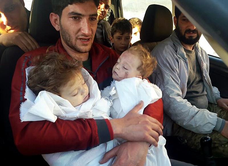 
              FILE -- In this Tuesday April 4, 2017 file photo, Abdel Hameed Alyousef, 29, holds his twin babies who were killed during a suspected chemical weapons attack, in Khan Sheikhoun in the northern province of Idlib, Syria. France's foreign minister says chemical analysis of samples taken from a deadly sarin gas attack in Syria shows that the nerve agent used "bears the signature" of President Bashar Assad's government and shows it was responsible. Jean-Marc Ayrault says France now knows "from sure sources" that "the manufacturing process of the sarin that was sampled is typical of the method developed in Syrian laboratories." But Kremlin promptly denounced the French report. (Alaa Alyousef via AP, File)
            