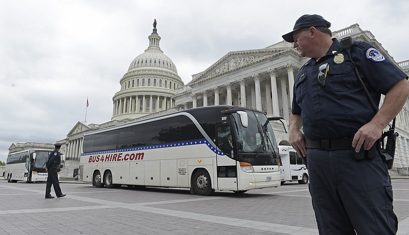 
              Capitol Hill Police officers stand guard as buses with Senators aboard depart Capitol Hill in Washington, Wednesday, April 26, 2017, headed to the White House to get a briefing on North Korea. (AP Photo/Susan Walsh)
            
