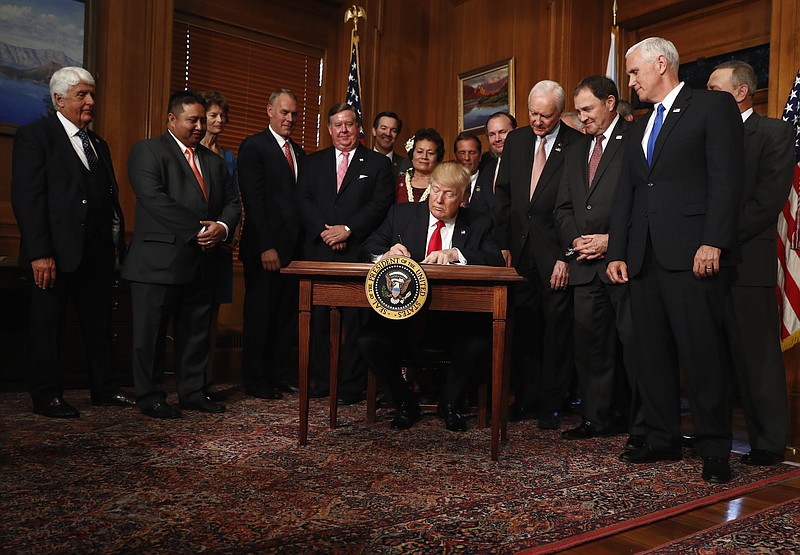 
              President Donald Trump signs an Antiquities Executive Order during a ceremony at the Interior Department in Washington, Wednesday, April, 26, 2017. President Donald Trump is asking for a review of the designation of tens of millions of acres of land as "national monuments." (AP Photo/Carolyn Kaster)
            