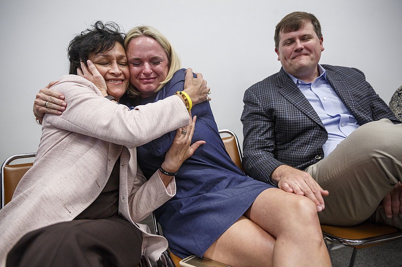 Dr. Elaine Swafford, left, and Kelly Alling, center, hug next to Ted Alling after their charter school, Chattanooga Preparatory School, was approved by the Hamilton County Board of Education during a special session on Thursday, April 27, 2017, in Chattanooga, Tenn. The board also approved a balanced budget to be sent to the county commission.