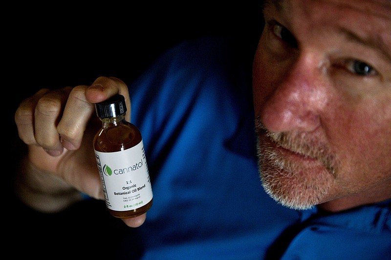 
              In this Monday, April 17, 2017 photo, Georgia State Rep. Allen Peake, R - Macon, displays a bottle of cannabis oil in his office in Macon, Ga. Peake is at the center of a semi-legal statewide medical cannabis distribution network. Though he successfully championed the creation and expansion of the medical marijuana program in Georgia, there is still no legal way for patients to obtain the low-THC cannabis oil. So Peake is taking matters into his own hands. (AP Photo/David Goldman)
            