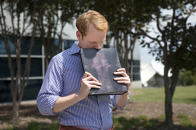 
              FILE - In this Wednesday, Aug. 26, 2015, file photo, WDBJ news anchor Chris Hurst pauses as he is overcome with emotion while holding a photo album that was created by fellow reporter and girlfriend Alison Parker, in Roanoke, Va. Hurst was living with Alison Parker when she and cameraman Adam Ward were fatally shot by a former co-worker while reporting for WDBJ-TV in August 2015. Hurst was living with Alison Parker when she and cameraman Adam Ward were fatally shot by a former co-worker while reporting for WDBJ-TV in August 2015. Hurst said he's seeking a Virginia state House seat to give back to the community that helped him through his darkest days. (Erica Yoon/The Roanoke Times via AP, File)
            