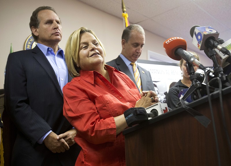 
              FILE - In this Wednesday, Aug. 12, 2015, file photo, U.S. Rep. Ileana Ros-Lehtinen, R-Fla., center, listens to a question from the media as she is joined by U.S. Rep. Mario Diaz-Balart, R-Fla., right, and his brother, former Congressman Lincoln Diaz-Balart, during a news conference, in Miami. Ros-Lehtinen of Florida, the first Cuban-American elected to Congress, is retiring at the end of her term next year, saying it's time to move on after 38 years in office. The Miami Herald first reported the retirement Sunday, April 30, 2017. (AP Photo/Wilfredo Lee, File)
            