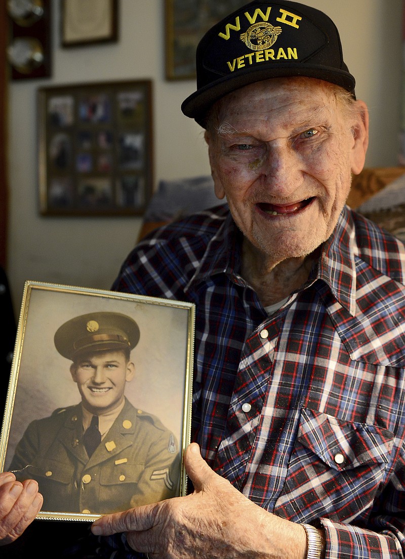 
              In this April 12, 2017 photo, World War II veteran Raymond Osborne  holds his U.S. Army photo at his home in Jackson, Tenn. After seeing his uncle’s $21 check from the National Guard, 17-year-old Raymond Osborne wanted to leave his job as a farmer on his family’s farm in Jackson and join the Army National Guard in 1940. The only problem was, Osborne could not legally join the Guard until he was 18. (Kenneth Cummings/The Jackson Sun via AP)
            