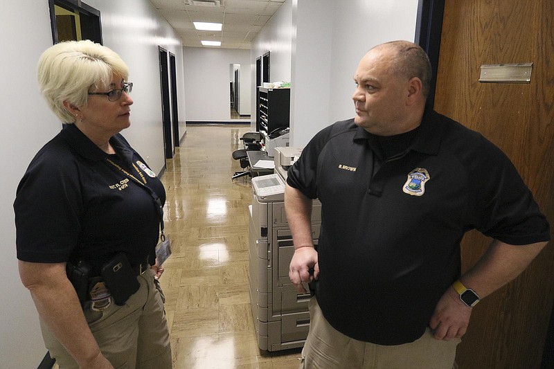 Staff Photo by Dan Henry / The Chattanooga Times Free Press- 4/27/17. Sgt. Rebecca Crites speaks to Detective Brad Brown as he works on sorting evidence that was found in recent car and storage unit break ins on Thursday, April 27, 2017. 