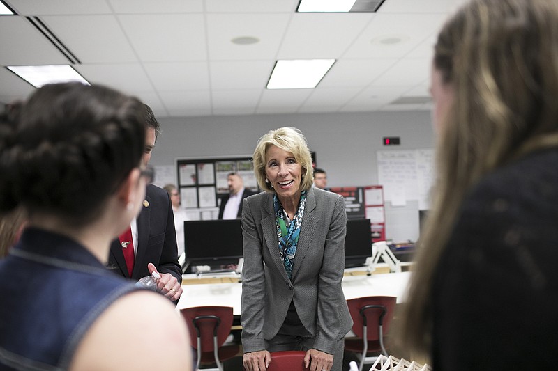 Education Secretary Betsy DeVos talks with students in an engineering and robotics class at Van Wert High School in Van Wert, Ohio, on April 20. DeVos' own department rendered judgment on the District of Columbia's school choice program as not having improved student achievement, and possibly worsening it. New York Times file photo