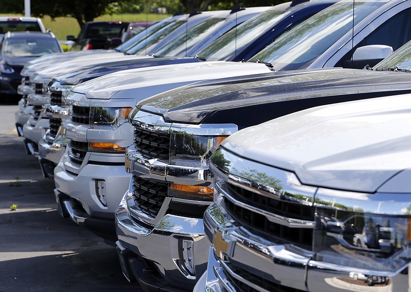 In this Wednesday, April 26, 2017, photo, Chevrolet trucks are lined up at a Chevrolet dealership in Richmond, Va. Analysts expect the auto industry to post a fourth straight month of lower sales as the pace of sales cools after last year's record. (AP Photo/Steve Helber)