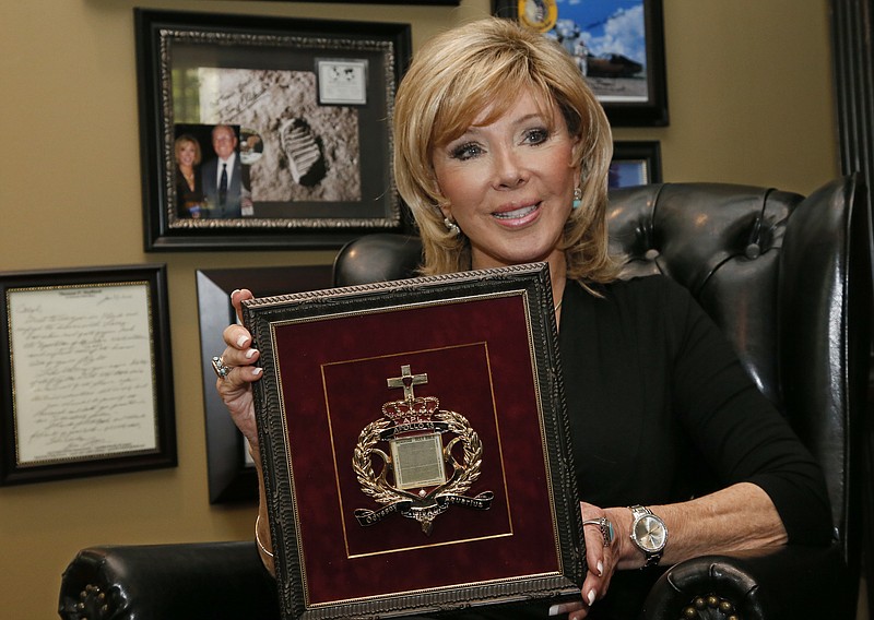 
              FILE - In this Tuesday, April 18, 2017 file photo, Carol Mersch holds a copy of a microfilm Bible that flew in orbit around the moon on Apollo 13 during an interview in her home in Tulsa, Okla. An Oklahoma judge has awarded 10 microfilm Bibles that NASA launched into space to Mersch, who fought a legal battle with a Texas agency over who owned the tiny books.  (AP Photo/Sue Ogrocki, File)
            