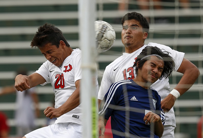 Dalton's Domingo Granados, left, and Tony Saldana try to head the ball into the goal around Effingham County's Javier Mendoza during Wednesday's match at Harmon Field in Dalton, Ga. The Cats won 7-0 to reach the quarterfinals of the Class AAAAAA state playoffs.