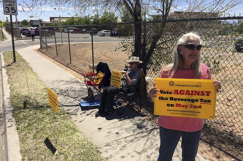 
              Coca-Cola Bottling Co. of Santa Fe Vice President Kathy Hart, 65, right, urges voters to reject a tax on sugary beverages outside a polling center in Santa Fe, N.M., on Tuesday, May 2, 2017. Voters in New Mexico's capital city were deciding whether to add a tax on sugary sodas and other sweetened beverages that would follow the examples of several cities across the country. The proposed tax in Santa Fe would pay to expand early childhood education. (AP Photo/Morgan Lee)
            