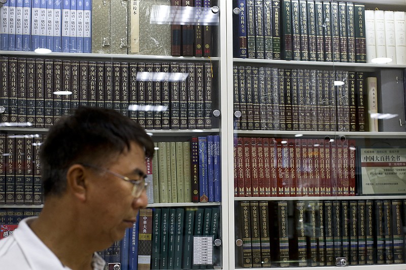 
              A Chinese man walks by a cabinets displaying Chinese encyclopedias at a book store in Beijing, Thursday, May 4, 2017. China is compiling a free online encyclopedia to rival Wikipedia, but it will likely only give Beijing's official version of sensitive historical events, and the public won't be able to write or edit it. (AP Photo/Andy Wong)
            