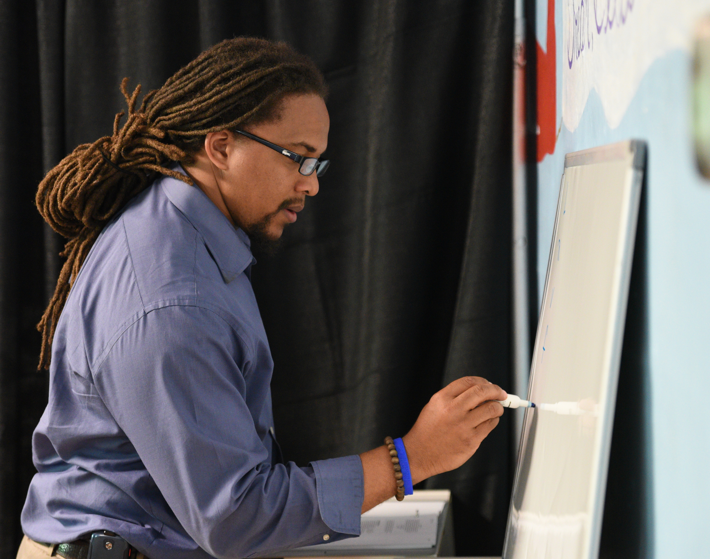 David Yancey writes on the board while teaching a music-based physics lesson Wednesday, April 26, 2017 at Temple of Faith Deliverance Church.