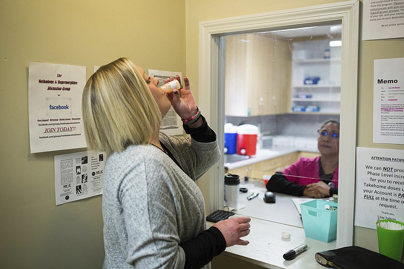 In this March 8, 2017, photo, Ashley Gardner, 34, takes a dose of methadone at Counseling Solutions of Chatsworth, Ga. Gardner, 34-year-old woman said her addiction started in the seventh grade when she wanted to numb the pain after she was sexually assaulted. She was assaulted another time, and saw both fathers of her two of her children die from an opioid overdose. (AP Photo/Kevin D. Liles)