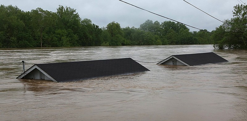 
              Two rental houses look underwater next to the Meramec River on Opps Lane in Fenton, Mo., Wednesday, May 3, 2017. Heavy rains have swollen many rivers to record levels in parts of Missouri, Illinois, Oklahoma and Arkansas. Five deaths have been blamed on flooding in Missouri, while hundreds of people have been displaced and thousands more are potentially in harm's way. (J.B. Forbes/St. Louis Post-Dispatch via AP)
            