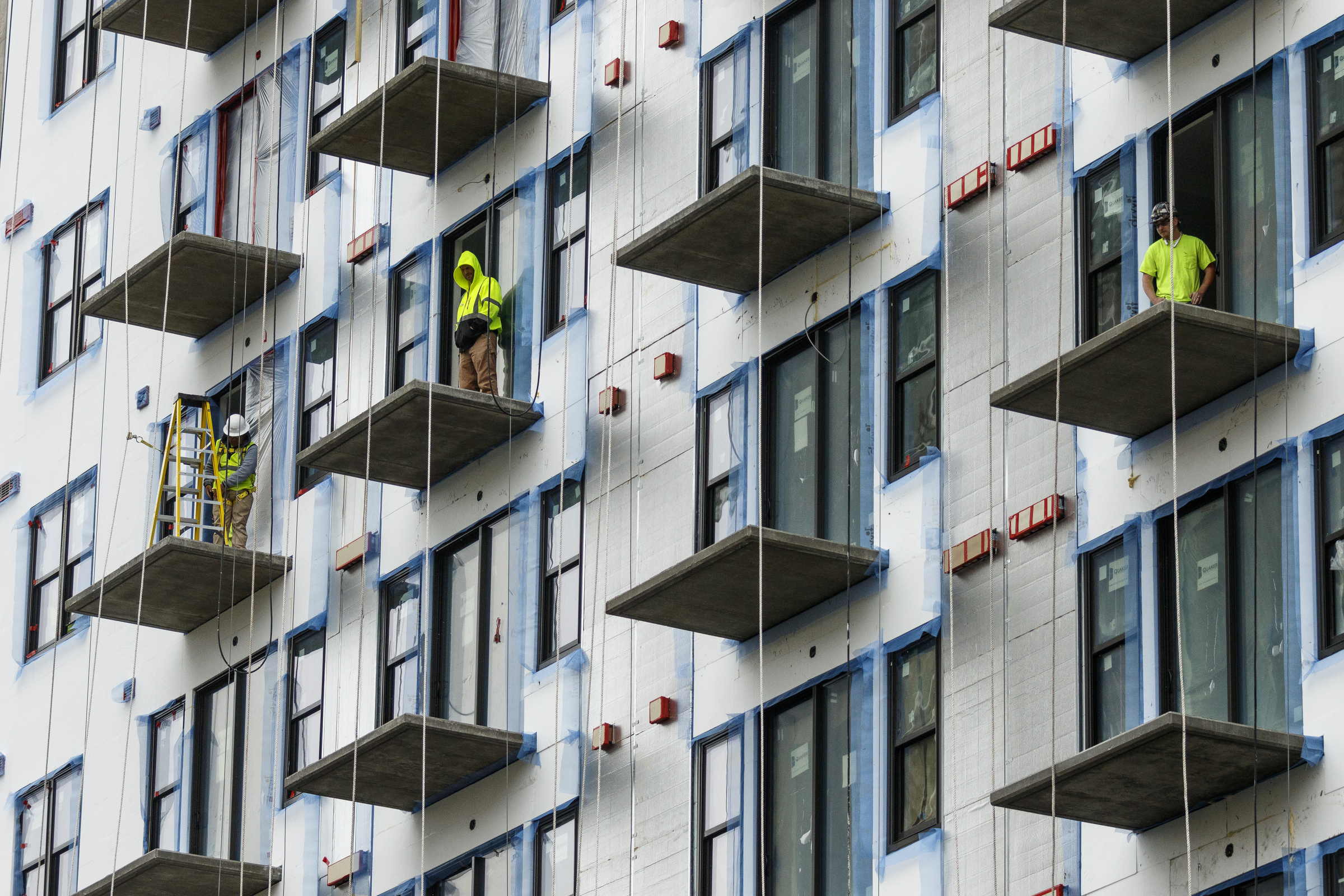 Construction workers watch from the incomplete balconies of apartments on Market Street during the annual Armed Forces Day Parade on Market Street on Friday, May 5, 2017, in Chattanooga, Tenn. This year's parade highlighted the United States Air Force.