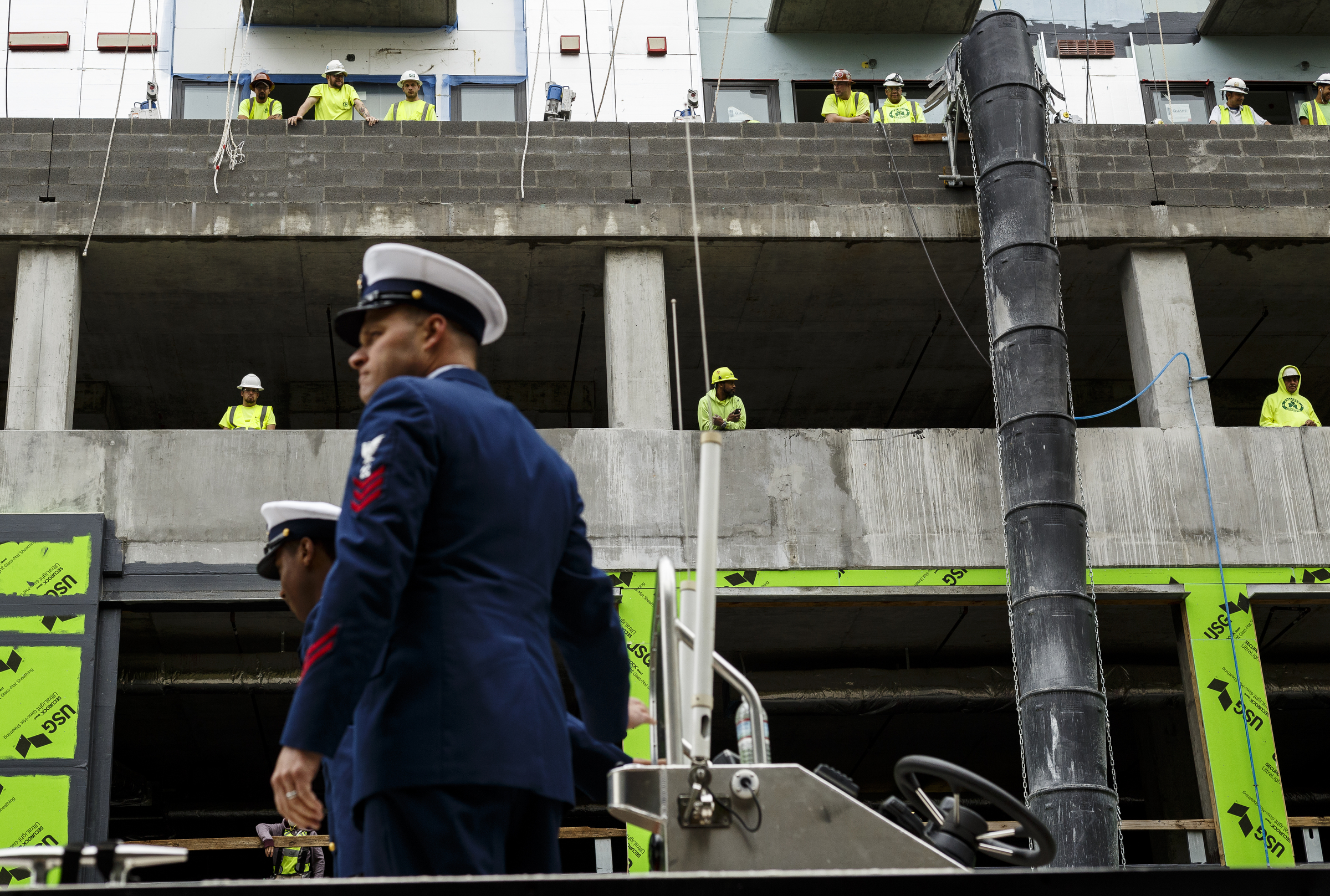 Construction workers watch a Coast Guard float pass from the incomplete balconies of apartments on Market Street during the annual Armed Forces Day Parade on Market Street on Friday, May 5, 2017, in Chattanooga, Tenn. This year's parade highlighted the United States Air Force.