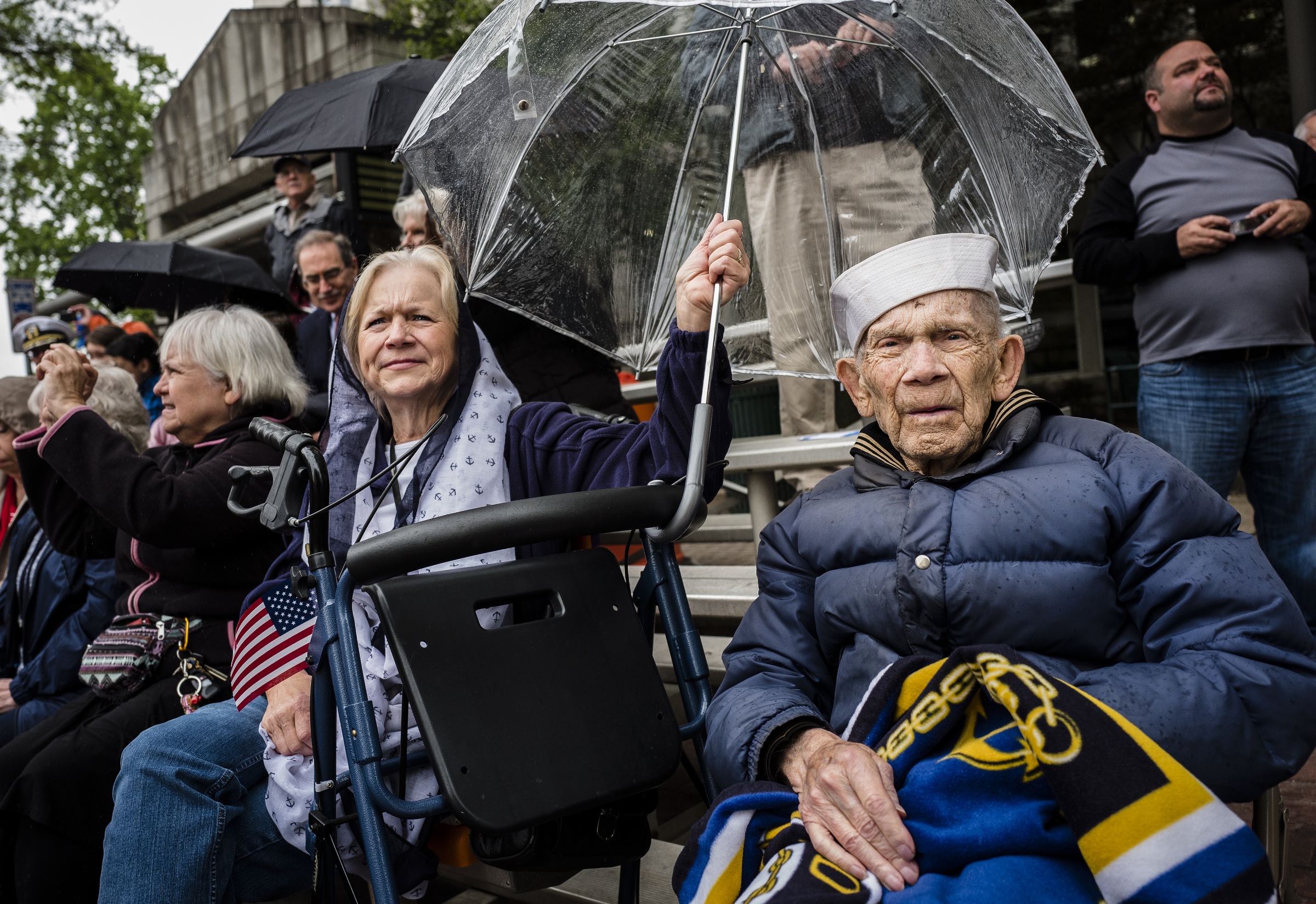 Carol Clark, center, holds an umbrella for her father Con Crabb, 90, a U.S. Navy World War II veteran, as they watch the annual Armed Forces Day Parade on Market Street on Friday, May 5, 2017, in Chattanooga, Tenn. This year's parade highlighted the United States Air Force.