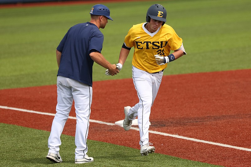 Caleb Longley, right, is congratulated on his way to home plate during an ETSU baseball game. Longley played at Walker Valley High School and went on to Cleveland State before joining the Buccaneers last season.