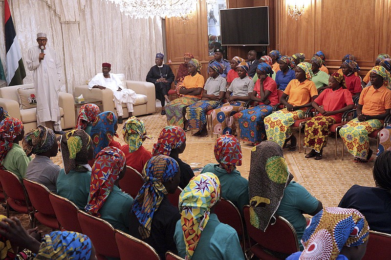 
              In this photo released by the Nigeria State House, Nigeria's President, Muhammadu Buhari, left, meets with Chibok school girls recently freed from Nigeria Extremist captivity in Abuja, Nigeria, Sunday, May 7, 2017. Five Boko Haram commanders were released in exchange for the freedom of 82 Chibok schoolgirls kidnapped by the extremist group three years ago, a Nigerian government official said Sunday, as the girls were expected to meet with the country's president and their families. (Bayo Omoboriowo/Nigeria State House via AP)
            