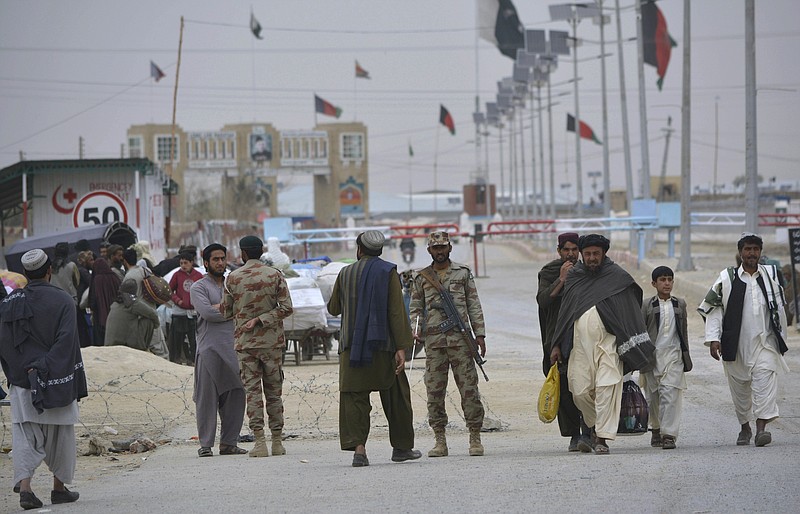 
              FILE -- In this March 20, 2017 file photo, Pakistani paramilitary soldiers stand guard while people wait for the opening of the  border crossing in Chaman, Pakistan. Pakistan says its forces killed at least 50 Afghan troops and destroyed five checkpoints in clashes along the disputed border two days earlier, while Afghanistan dismissed the account, saying only two border police and a civilian were killed. The two armies traded fire Friday, May 5, 2017, around the Chaman border crossing, which has been closed by Pakistan, stranding people on both sides. (AP Photo/Matiullah Achakzai, File)
            