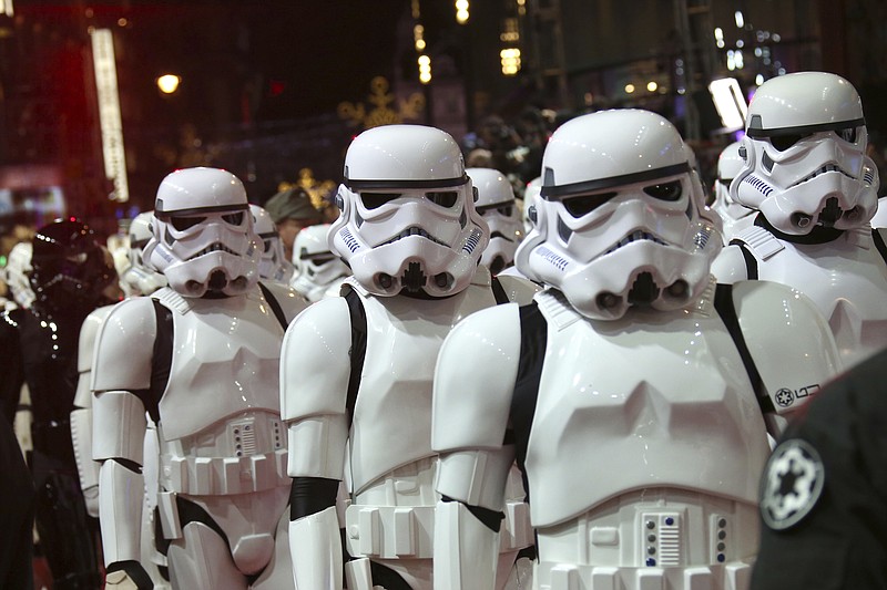 FILE - In this Dec. 16, 2015. file photo, people dressed as stormtroopers walk on the red carpet upon arrival at the European premiere of the film 'Star Wars: The Force Awakens' in London. Multiple stories on sites resembling local affiliate TV stations have published false casting calls claiming the a Star Wars movie is going to be filmed towns across the United States, interchanging the name of the town and promoting a new movie about a previously unknown planet in the Star Wars universe. The only Star Wars movie in production in May 2017 is the untitled Han Solo Film, which began shooting in January outside London. (Photo by Joel Ryan/Invision/AP, File)