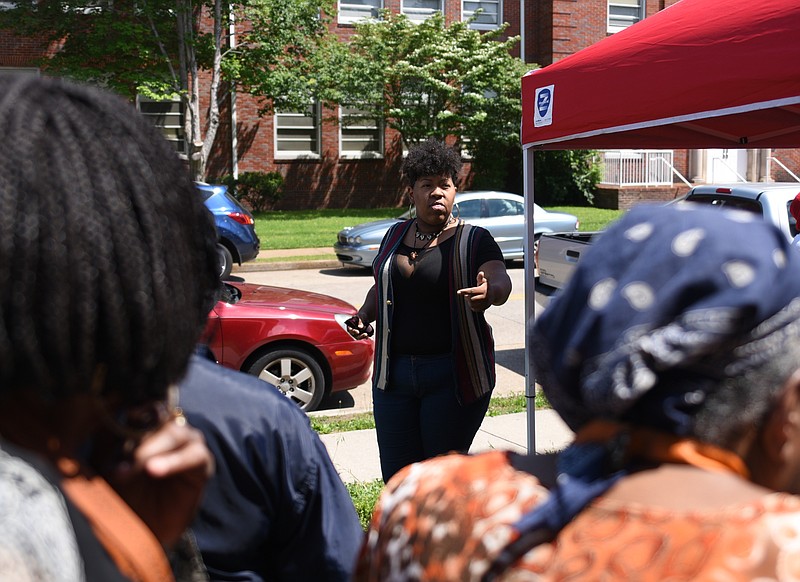 Aysja Pryor talks to people who have come to get food Tuesday, May 9, 2017 on Grove Street. Pryor is angry that the neighborhood grocery store was shut down.