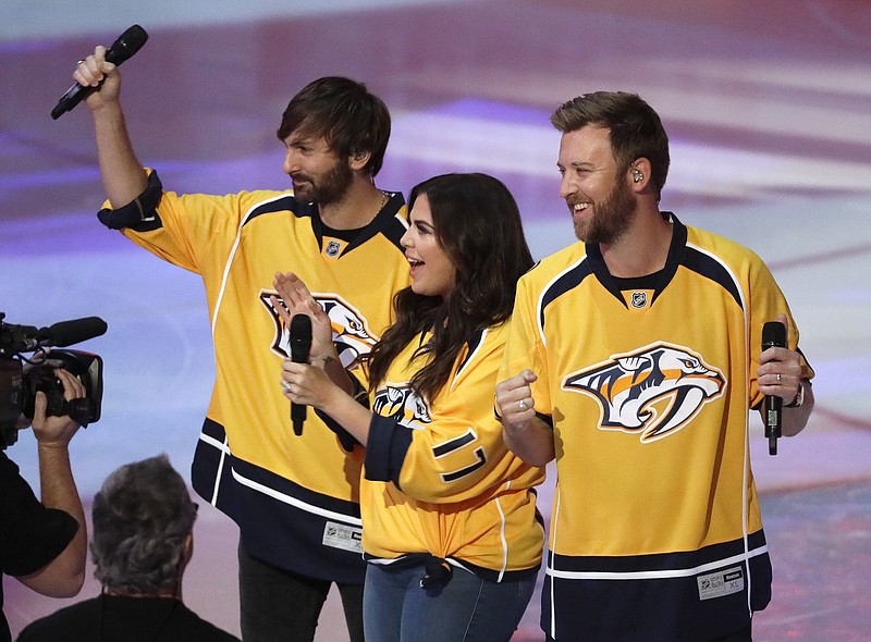 
              The country group Lady Antebellum performs the national anthem before Game 6 of a second-round NHL hockey playoff series between the Nashville Predators and the St. Louis Blues Sunday, May 7, 2017, in Nashville, Tenn. From left to right, are: Dave Haywood, Hillary Scott and Charles Kelley. (AP Photo/Mark Humphrey)
            