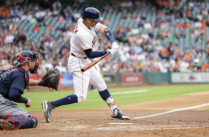 Houston Astros' Carlos Correa, right, hits a three-run home run as Atlanta Braves catcher Tyler Flowers reaches for the pitch during the first inning of a baseball game, Tuesday, May 9, 2017, in Houston. (AP Photo/David J. Phillip)