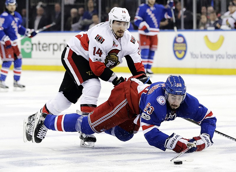 New York Rangers' Mika Zibanejad (93) and Ottawa Senators' Alex Burrows (14) fights for control of the puck during the second period of Game 6 of an NHL hockey Stanley Cup second-round playoff series Tuesday, May 9, 2017, in New York. (AP Photo/Frank Franklin II)