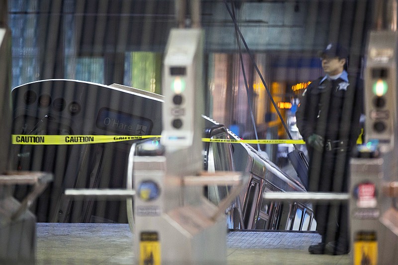 
              FILE - In this March 24, 2014, file photo, a police officer stands near a Chicago Transit Authority train car that derailed and scaled an escalator at the underground O'Hare Airport CTA station in Chicago. A jury on Friday, May 5, 2017, awarded more than $6 million to Yolanda Montes who was seriously injured in the crash. (AP Photo/Andrew A. Nelles, File)
            