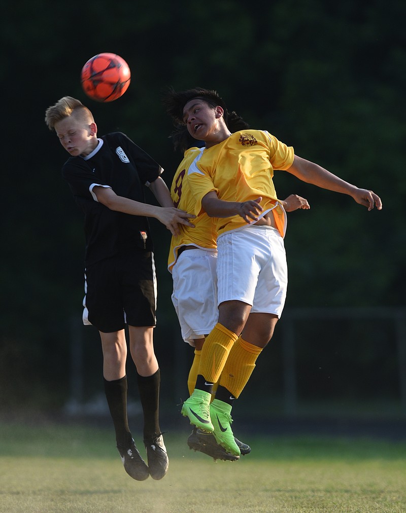 Howard's Kylder Vasquez, right, challenges Hixson's Nathan Hunt in heading the ball Thursday in the District 6-A/AA soccer championship match. Host Howard won 2-0.