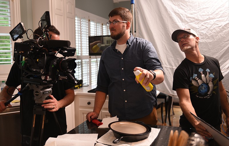 Grady Upchurch, left, gets ready to film Kris Stubblefield, product and test kitchen coordinator for Lodge Manufacturing, as Glenn Stegall, right, assists in a home at Heritage Landing.