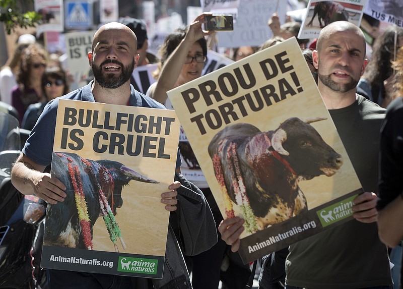 
              Protesters carry banners during an anti bullfighting demonstration march in Madrid, Spain, Saturday, May 13, 2017. Thousands marched though the center of the city to call for a ban of bullfighting. Banner on right reads 'Stop the torture'. (AP Photo/Paul White)
            