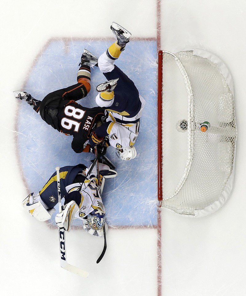 
              Nashville Predators' Mattias Ekholm (14) collides with Anaheim Ducks' Ondrej Kase (86) as they battle for the puck by the goal during the first period of Game 2 of the Western Conference final in the NHL hockey Stanley Cup playoffs, Sunday, May 14, 2017, in Anaheim, Calif. (AP Photo/Chris Carlson)
            