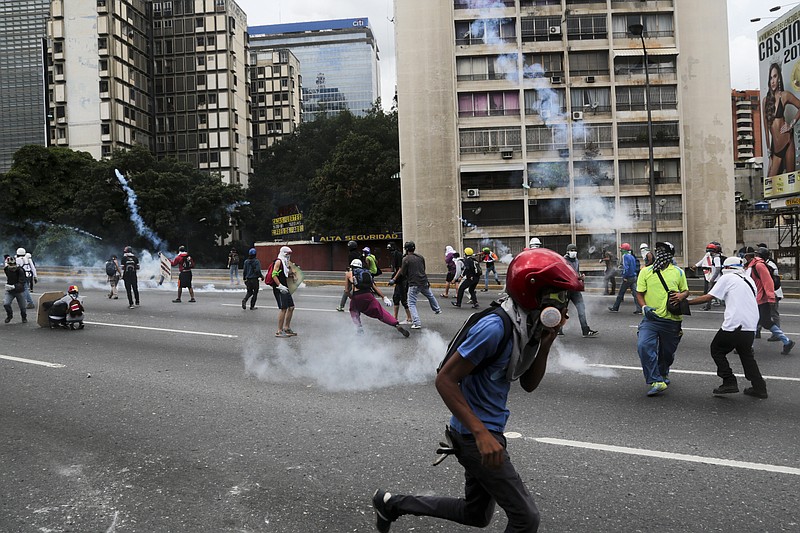 
              Anti-government protesters face off with security forces during a march against President Nicolas Maduro in Caracas, Venezuela, Saturday, May 13, 2017. An anti-government protest movement has drawn masses of people into the streets nearly every day since March. (AP Photo/Fernando Llano)
            