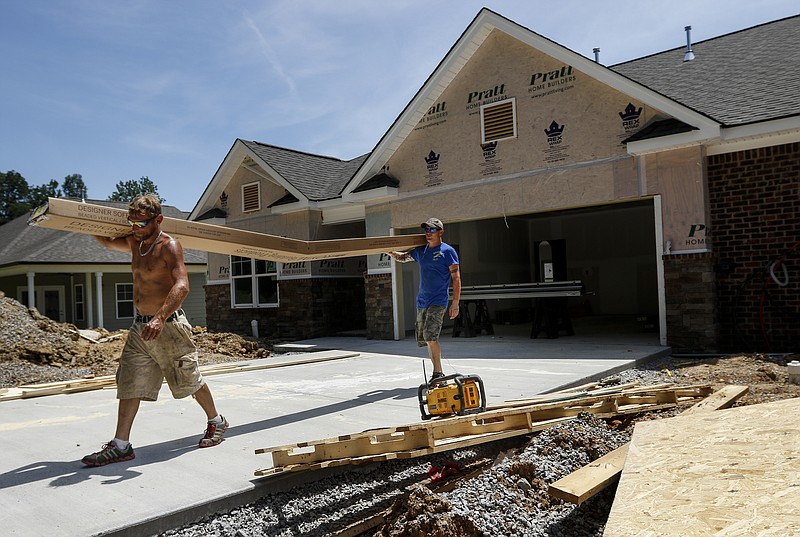 Charles Henley, left, and Boray Blackmon carry a box of scaffolding from construction of a new townhome in the Brookside Commons subdivision in East Brainerd on Tuesday, May 16, 2017, in Chattanooga, Tenn. New home starts are up about 9 percent over last year in the first quarter.