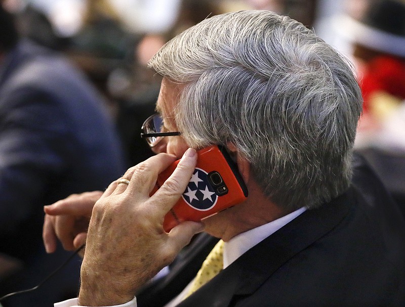 Sen. Todd Gardenhire, R-Chattanooga, talks on a phone with a Tennessee flag cover during a Senate session Wednesday, May 10, 2017, in Nashville, Tenn. (AP Photo/Mark Humphrey)

