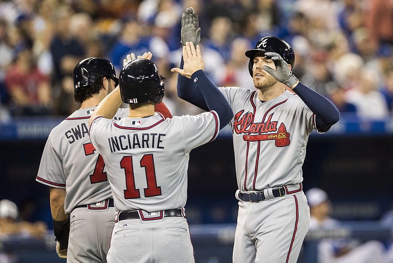 Atlanta Braves' Freddie Freeman, right, celebrates his three-run home run with teammates Ender Inciarte (11) and Dansby Swanson during the sixth inning of a baseball game against the Toronto Blue Jays in Toronto, Monday May 15, 2017. (Mark Blinch/The Canadian Press via AP)