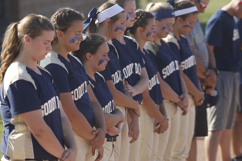 Soddy-Daisy softball players bow their heads during a moment of silence before their prep softball game at Soddy-Daisy High School for a fellow student who was found dead on Wednesday, May 17, 2017, in Soddy-Daisy, Tenn.