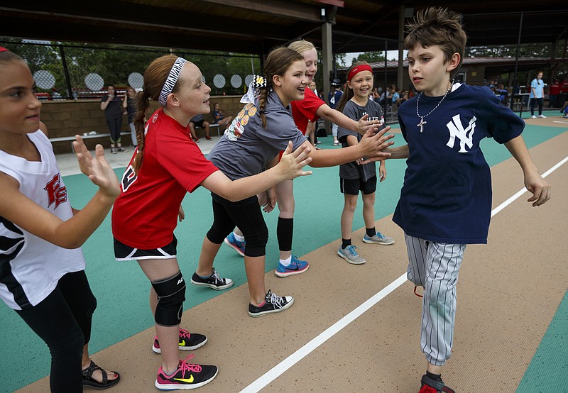 Yankees player Hayden Brock claps hands with a group of local softball players as he runs the bases during a Miracle League ballgame at the Miracle Field on Saturday, May 21, 2016, in Rocky Face, Ga. Fundraising efforts are underway to bring a Miracle Field to Warner Park in Chattanooga.