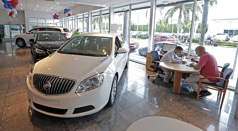 
              In this Wednesday, April 26, 2017, photo, client specialist Felipe A. Perdomo, left, closes a deal with customer John Tsialas at a GMC Buick dealership in Miami. U.S. household debt reached a record high in the first three months of 2017, topping the previous peak reached in 2008. Yet the nature of what Americans owe has changed since the Great Recession. Student and auto loans make up a larger proportion of household debt, while mortgages and credit card debt remain below pre-recession levels. (AP Photo/Alan Diaz)
            