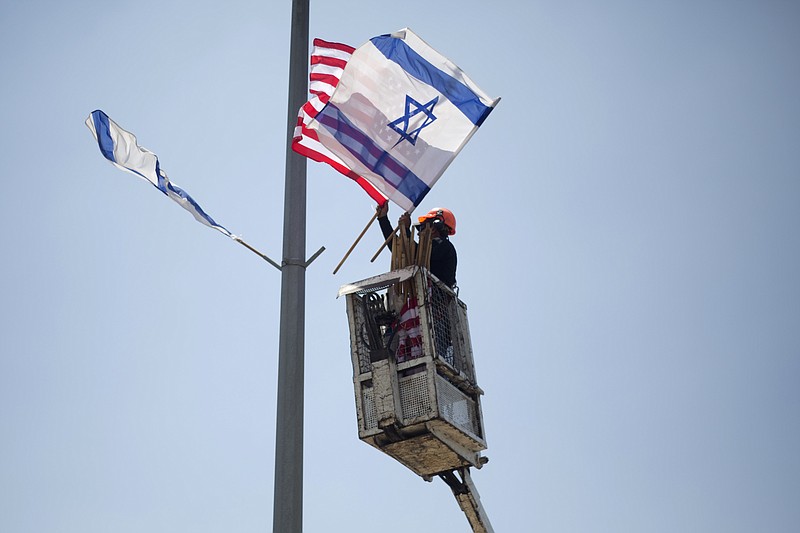 
              A worker hangs Israeli and American flags on a lamppost along a freeway leading to Jerusalem, days before a planned visit by President Donald Trump, Tuesday, May 16, 2017. The Israeli prime minister's office said it is seeking clarifications from Trump after an American official said the Western Wall is part of the West Bank. (AP Photo/Ariel Schalit)
            