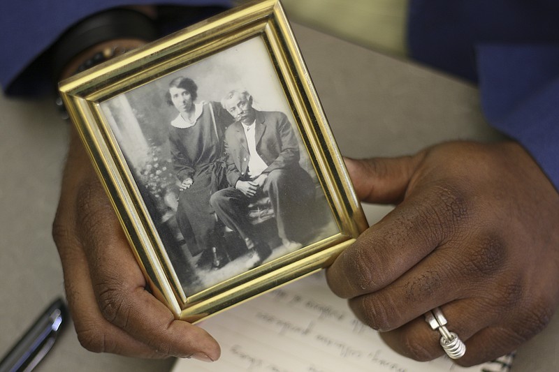 James McKissic holds a photograph of his great-grandparents, Pink, right, and Onie Wilson. Pink was Wilson Wood's youngest son.