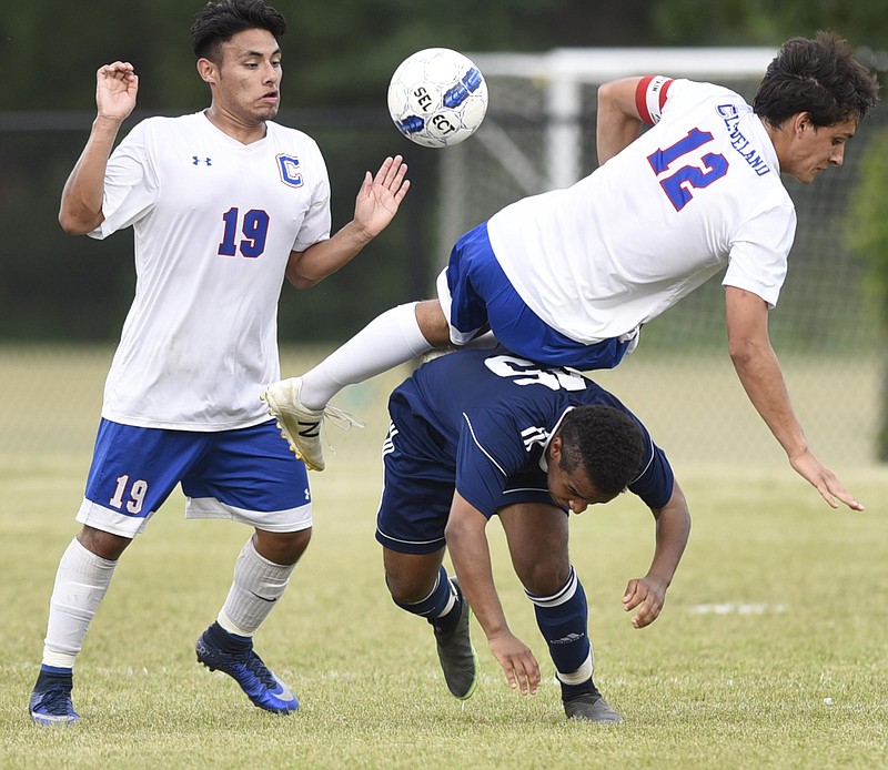 Cleveland's River Shaffer (12) is upended by a Cookeville player as Cleveland teammate Julio Gallegos (19) looks on.  The Cookeville Cavaliers visited the Cleveland Blue Raiders in TSSAA soccer action on May 18, 2017