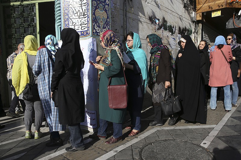 
              Iranian voters enter a polling station for the presidential and municipal councils elections in Tehran, Iran, Friday, May 19, 2017. Iranians began voting Friday in the country's first presidential election since its nuclear deal with world powers, as incumbent Hassan Rouhani faced a staunch challenge from a hard-line opponent over his outreach to the wider world. (AP Photo/Vahid Salemi)
            