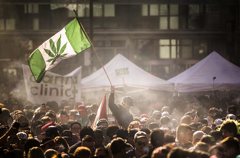 
              FILE- In this April 20, 2016, file photo, people smoke marijuana during a 4/20 cannabis culture rally in Toronto. The Canadian government, which introduced nationwide pot legalization legislation last month and expects to pass it next year, hopes to undercut the underground marijuana market with the lower age limit of 18 and not 21, an untested theory that is being closely watched around this country and in the U.S. (Mark Blinch/The Canadian Press via AP, File)
            