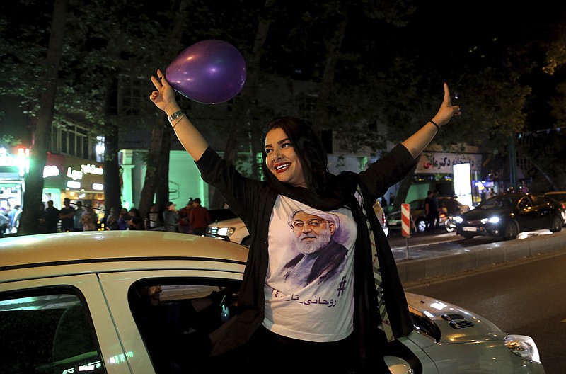 
              A supporter of Iranian President Hassan Rouhani wears a T-shirt with his image as she attends a street campaign ahead the May 19 presidential election in downtown Tehran, Iran, Wednesday, May 17, 2017. President Hassan Rouhani, a moderate, is seeking re-election in a vote that will largely serve as a referendum on his outreach to the West, which culminated in the 2015 nuclear deal with world powers. (AP Photo/Ebrahim Noroozi)
            