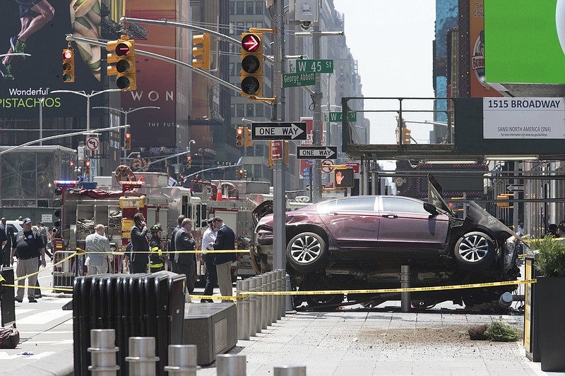 
              FILE - In this Thursday, May 18, 2017 file photo, a car rests on a security barrier in New York's Times Square after driving through a crowd of pedestrians, injuring at least a dozen people. A three-foot-tall piece of stainless steel in the ground ultimately stopped a speeding Honda Accord as it barreled down the crowded sidewalks of Times Square this week. In the wake of the rampage, some New Yorkers are calling for the installation of more protective bollards at the ends of city sidewalks to prevent similar incidents. (AP Photo/Mary Altaffer)
            