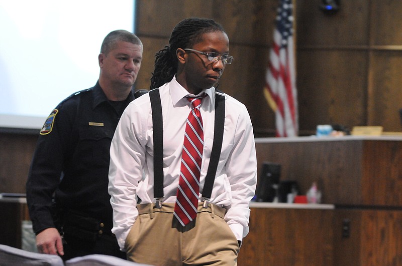 Defendant Dominique Greer, 21, is escorted into Judge Rebecca Stern's courtroom by Deputy Billy McGowan after a brief recess in the murder trial that began Tuesday. Greer is accused of killing Darrian Moore, age 21 at the time of his death, in 2010.